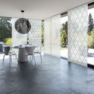 Großes Esszimmer mit Blick auf den Garten und weißen transparenten Schiebevorhängen