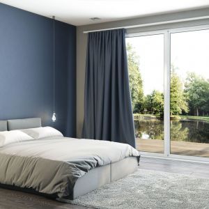 Schlafzimmer mit blauen Wänden und einem Bett in der Mitte, das eine ruhige und entspannende Atmosphäre schafft.