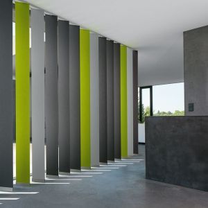 Modernes Büro mit vertikalen grünen und grauen Jalousien, die eine stilvolle und zeitgemäße Atmosphäre schaffen.