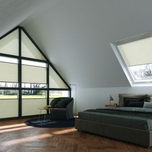 Schlafzimmer mit großem Fenster, das Tageslicht hereinlässt, und einem einladenden Bett in der Mitte des Raumes.
